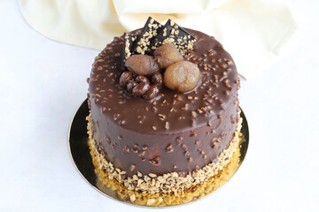 Chocolate and chestnut birthday cake on wooden background