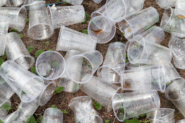 empty used plastic cups on the ground close up - environment pollution after marathon