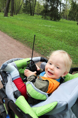 child playing with a toy car remote in a stroller