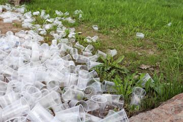 empty used plastic cups on the ground rubbish on the side of the road - environment pollution after...