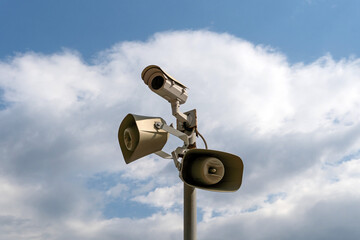 CCTV camera and sound alert system on the pole, against the sky