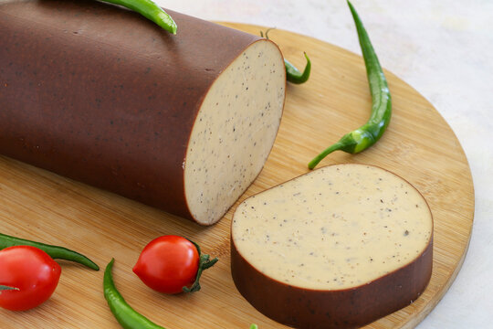 Smoked cheese with peppers on a white background. Local name biberli f&uuml;me peynir