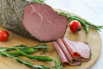 Roast beef on cutting board. Wooden background.