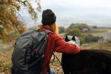 woman hiker in nature next to dog landscape travel to autumn forest