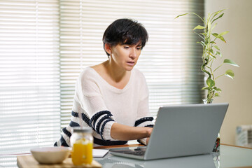 Woman teleworking from home with her laptop.