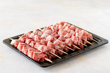 Raw Lamb skewers on a white wooden background. Meat background.