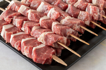 Raw Lamb skewers on a white wooden background. Meat background. Meat close-up