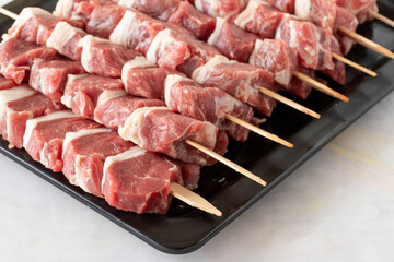 Raw Lamb skewers on a white wooden background. Meat background. Meat close-up