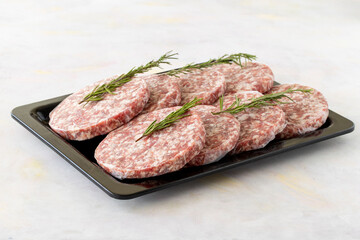 packaged raw beef burger meat on white wooden background. Meat background.