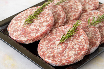 packaged raw beef burger meat on white wooden background. Meat background.