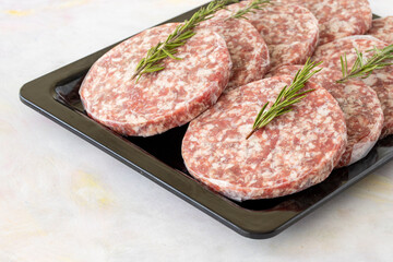 packaged raw beef burger meat on white wooden background. Meat background.