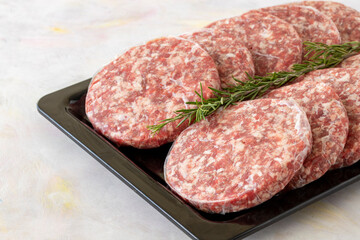 packaged raw beef burger meat on white wooden background. Meat background.