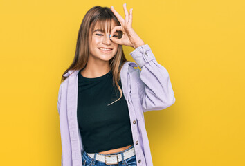 Teenager caucasian girl wearing casual clothes doing ok gesture with hand smiling, eye looking through fingers with happy face.