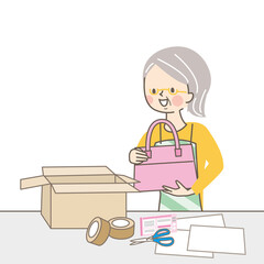 商品を包んで送るシニア女性