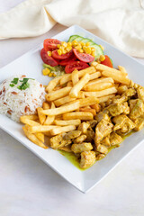 Chicken with curry sauce on a white wooden background. Local name köri soslu tavuk