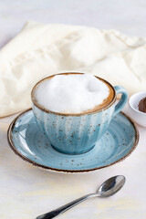 Foam cappuccino on a white wooden background