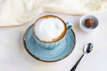 Foam cappuccino on a white wooden background