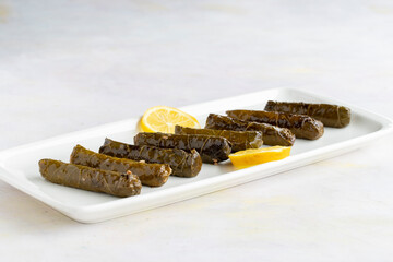 stuffed grape leaves on a white wooden background. Local name zeytinyağlı yaprak sarma