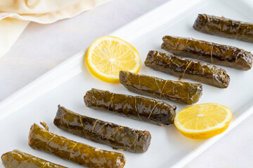 stuffed grape leaves on a white wooden background. Local name zeytinyağlı yaprak sarma