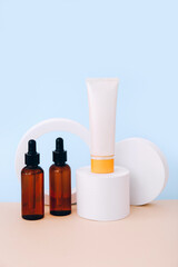 Trendy background with natural cosmetic skincare bottles on blue background. Product presentation.