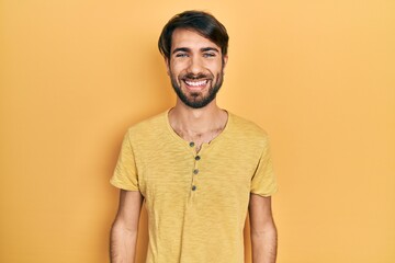 Young hispanic man wearing casual clothes looking positive and happy standing and smiling with a confident smile showing teeth