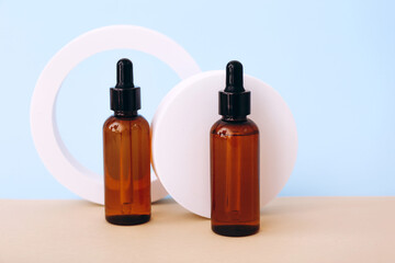 Trendy background with natural cosmetic skincare bottles on blue background. Product presentation.