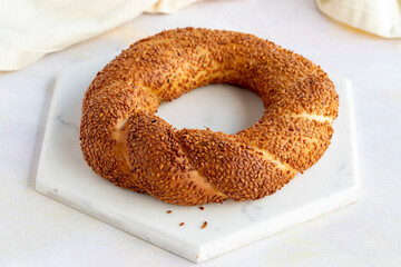 Bagel with sesame seeds on a white wooden background. Local name susamlı simit