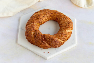 Bagel with sesame seeds on a white wooden background. Local name susamlı simit