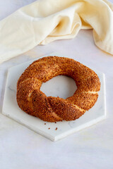 Bagel with sesame seeds on a white wooden background. Local name susamlı simit