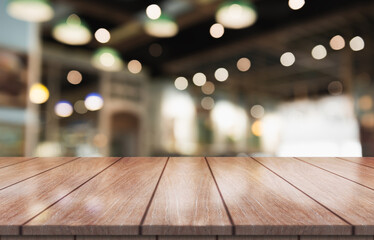 Empty wooden table top with lights bokeh on blur restaurant background.