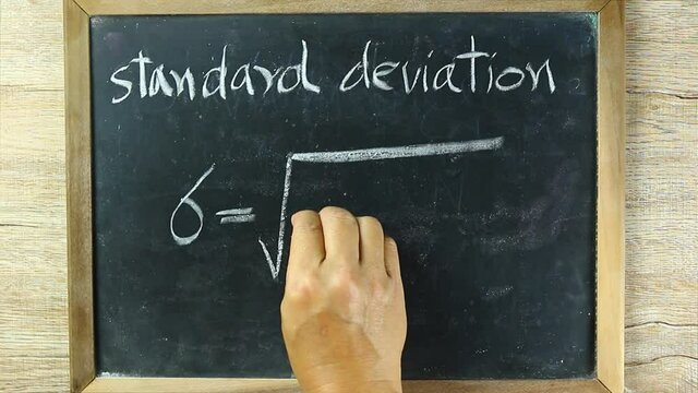 Man writing  Standard deviation formula on black board, in studio Chiangmai Thailand
