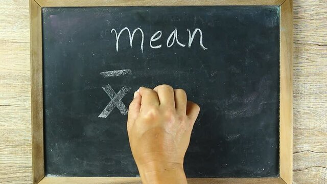 Man writing  Mean formula on black board, in studio Chiangmai Thailand