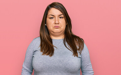 Fototapeta premium Beautiful brunette plus size woman wearing casual clothes depressed and worry for distress, crying angry and afraid. sad expression.