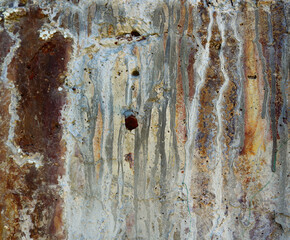 surface of a stone wall with multicolored rust grooves - abstract background for a mineral wallpaper