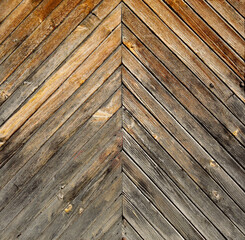 old wooden surface from a door with oblique boards in the shape of a triangle of wood with gradient discolored texture