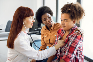 Preventive pediatricians examination before school or vaccination. Cheerful professional Caucasian...
