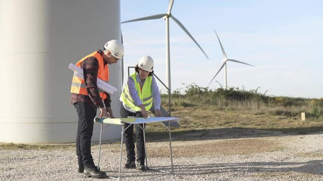 Renewable energy concept - Engineer people working at clean wind farm