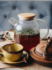 Pomegranate teapot and cup on the table in restaurant