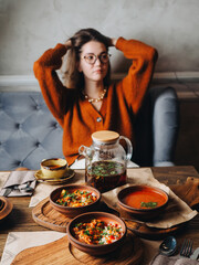 Girl pour black tea from glass teapot in restaurant