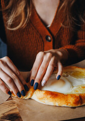 Khachapuri in Adjarian. How to eat correctly. Female hands