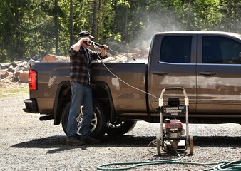 Man spray washing pickup truck - obrazy, fototapety, plakaty