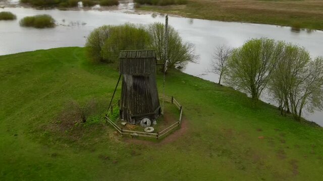 Panoramic aerial drone view of old vintage wooden windmill in spring summer time. Russian countryside. 