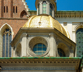 Obraz premium A close up on the rooftops of Wawel Castle in Cracow, Poland. The rooftops are richly decorated with gold and some small figures. Clear and blue sky above the city.