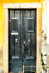 Green wooden door with door knocker hand shape.