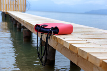Woman's bag overturned on top of a wooden pier, concept of violence against women