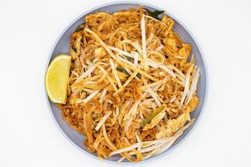 Delicious Pad Thai with a Lime on a Blue Plate with a White Background