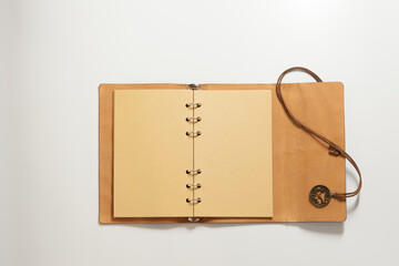 An open notebook with yellowed blank pages, a beautiful leather wrapper and decorative lacing...