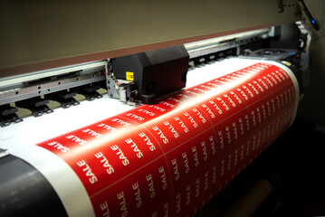 Printing stickers with the inscription sale on the printing press. Preparing for the night of sales...