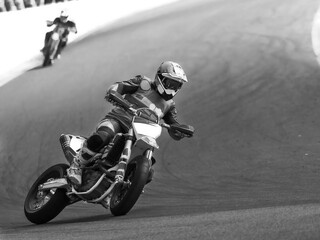 Supermoto rider in race on road. Drifting and sliding.