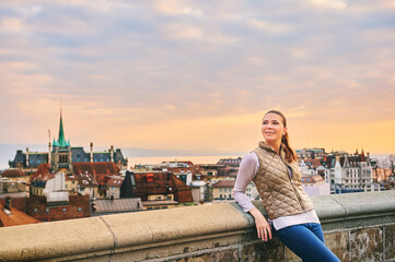 Outdoor portrait of beautiful young woman, european city landscape on background, Lausanne, Switzerland